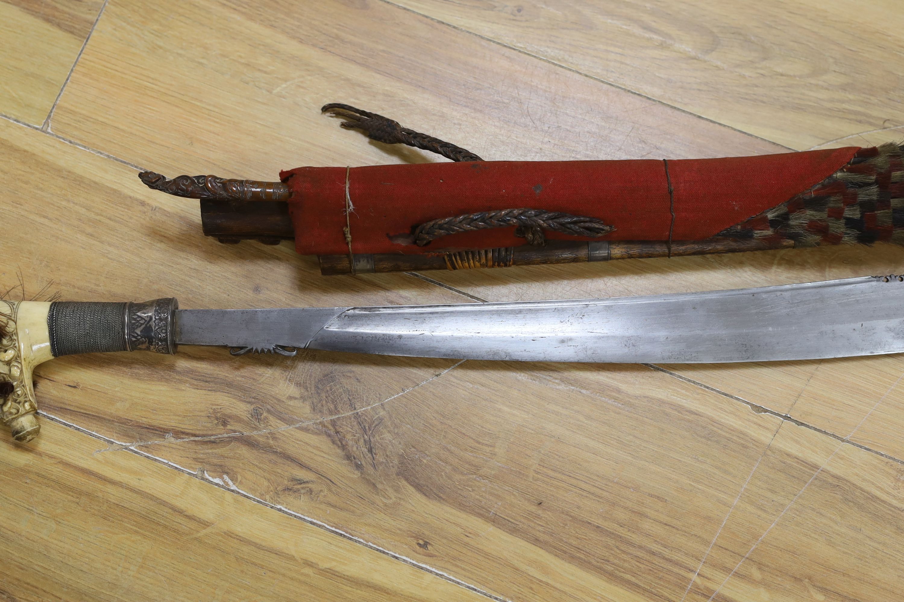 A Borneo 'headhunter's sword', a bone carving and feather swot (3), sword 77 cm long